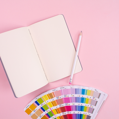 paint swatches and open notebook with pencil