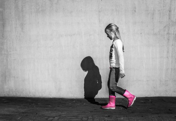 black and white image of a little girl, her boots are pink